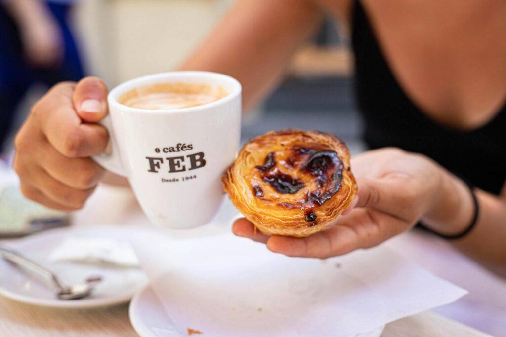 Enjoying a Pastel de nata tart and coffee