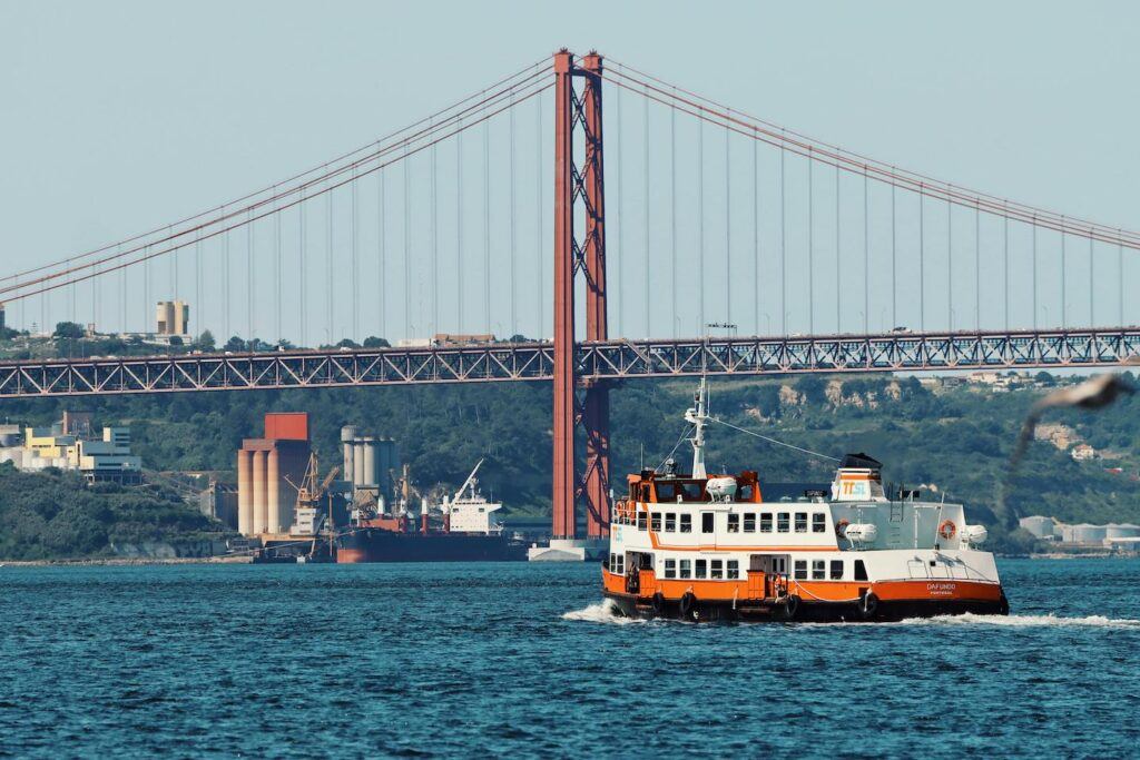 A boat passing beside a Bridge in Lisbon