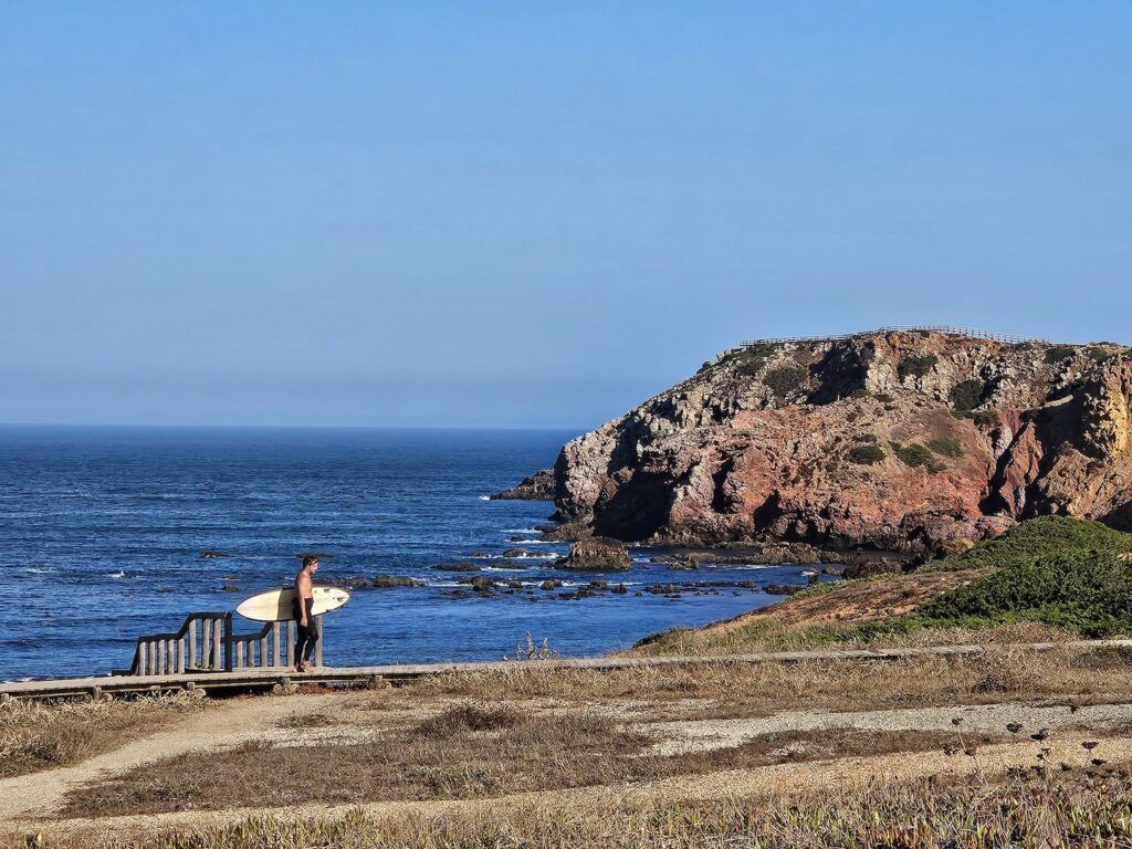 A person entering the water to go surfing in Portugal