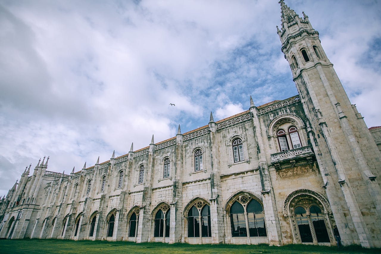 The Monsastery of Jerónimos in Lisbon Portugal seen from ground level with a cloudy sky in the background