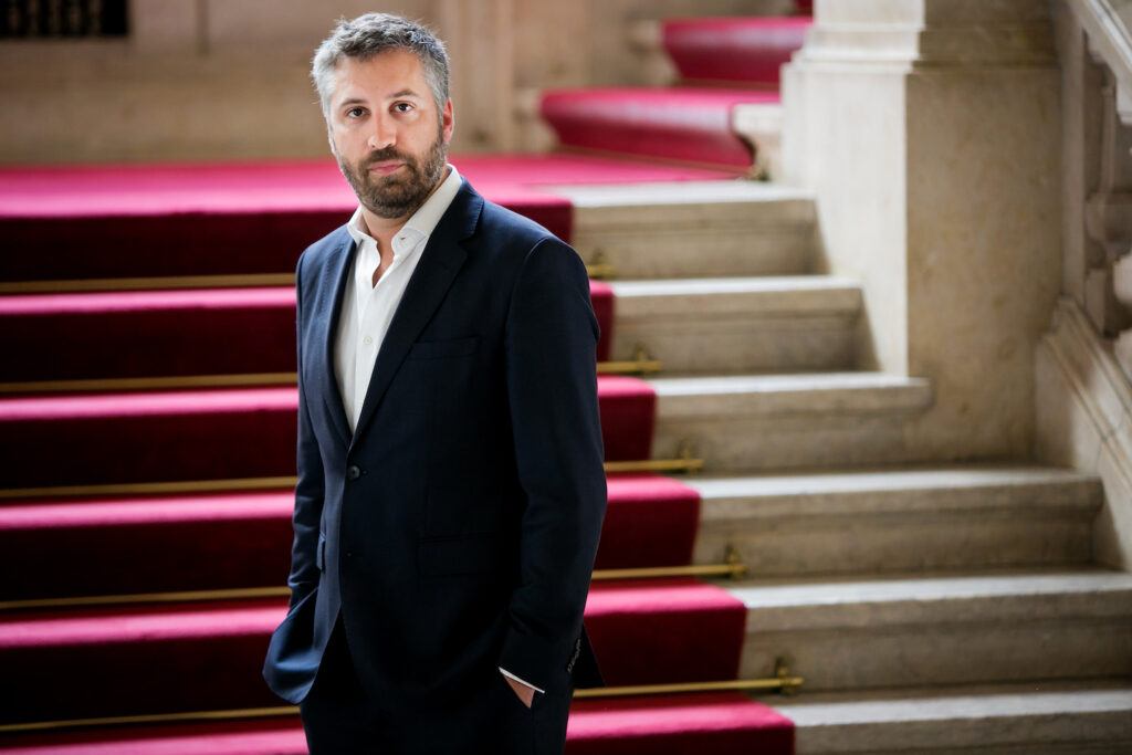 Pedro Nuno Santos standing in front of stairs with a red carpet.