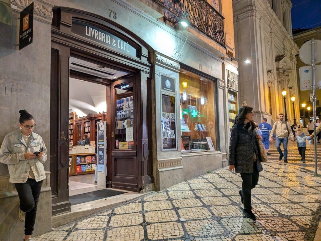 The entrance to Bertrand Bookshop in Lisbon seen in the evening with people on the street outside