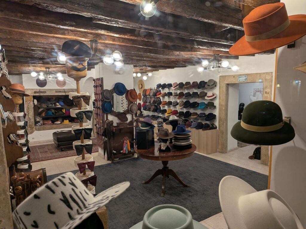 The interior of a hat shop in Lisbon with many hats on display all over the shop