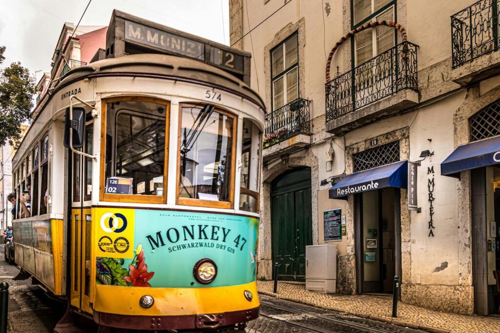 A tram car on a Lisbon street with an old building in the background