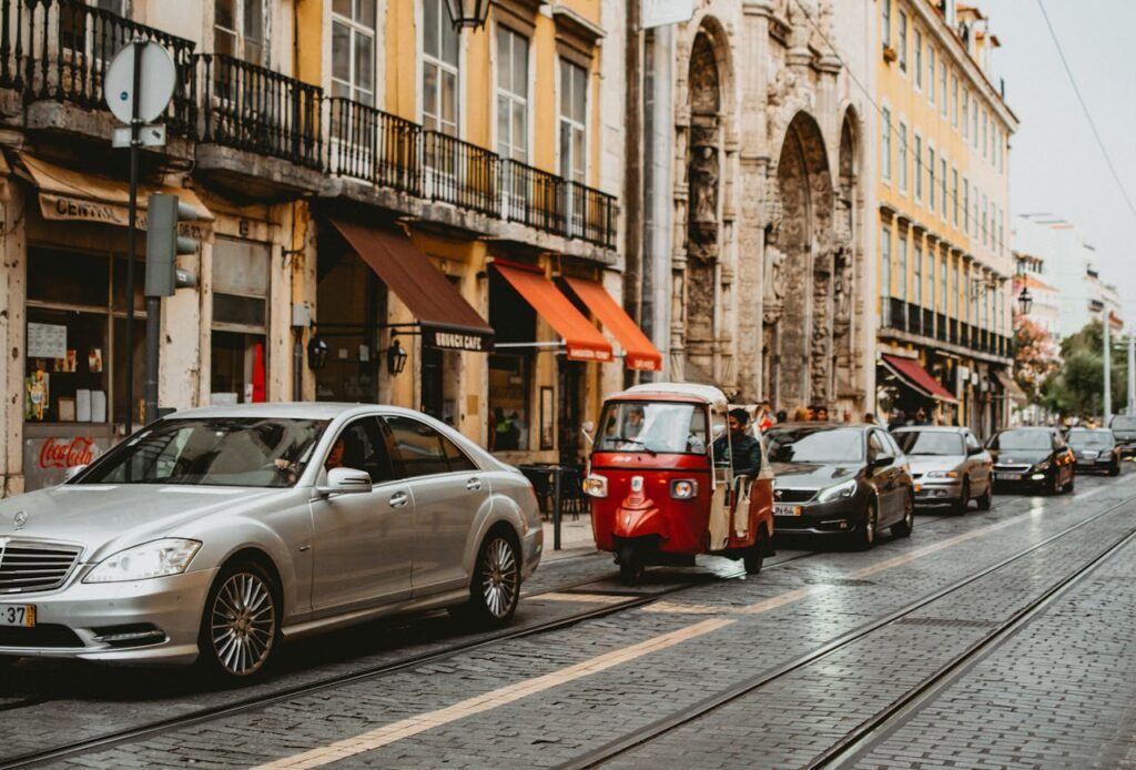 A street of shops with cars parked in Lisbon, Portugal.