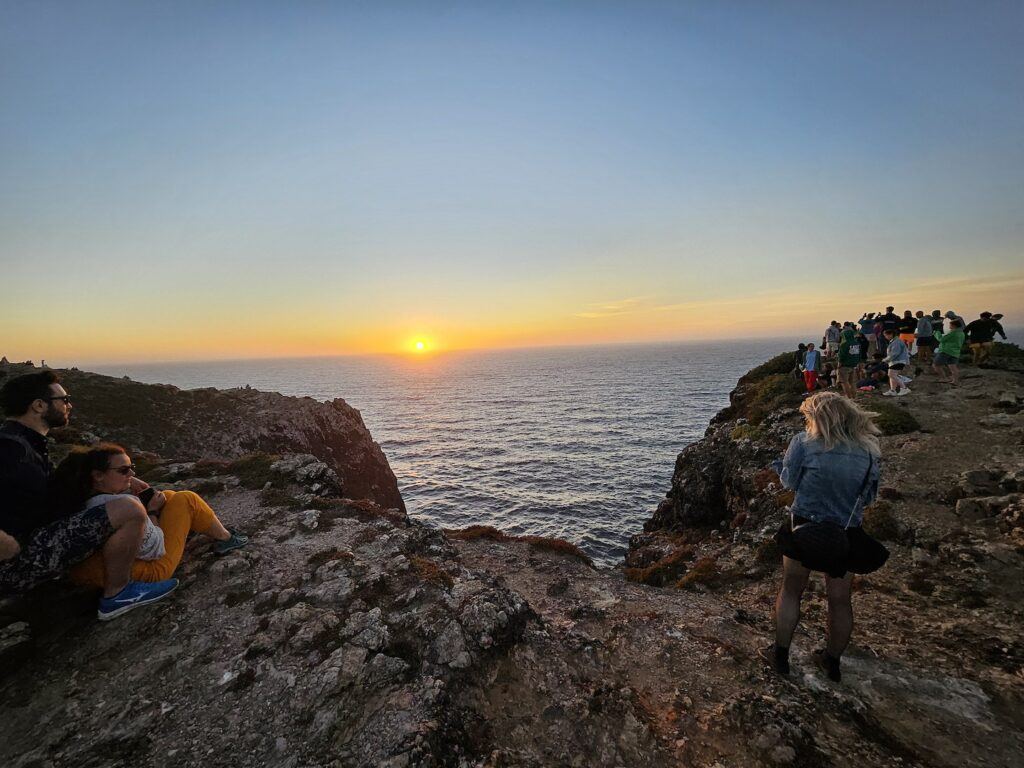 People gathered on a cliff top to watch the sunset at St Vincents Point, Portugal