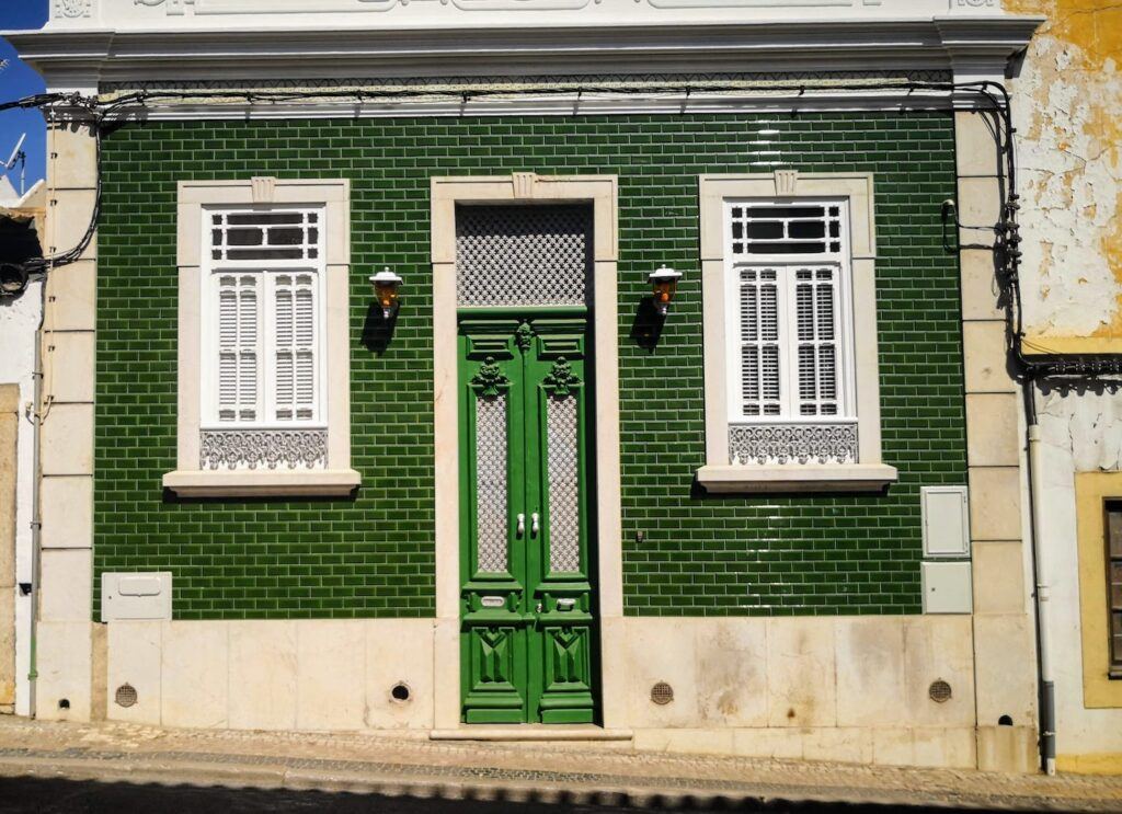 A traditional Portuguese urban home with green tiles and a green door