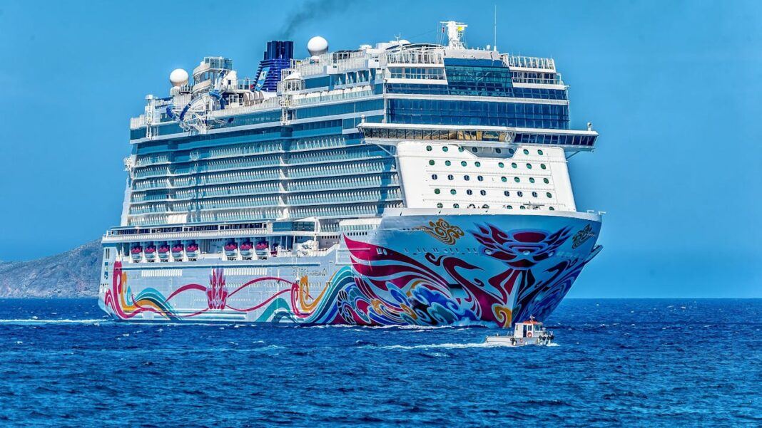 A large , white and colourful cruise ship at sea