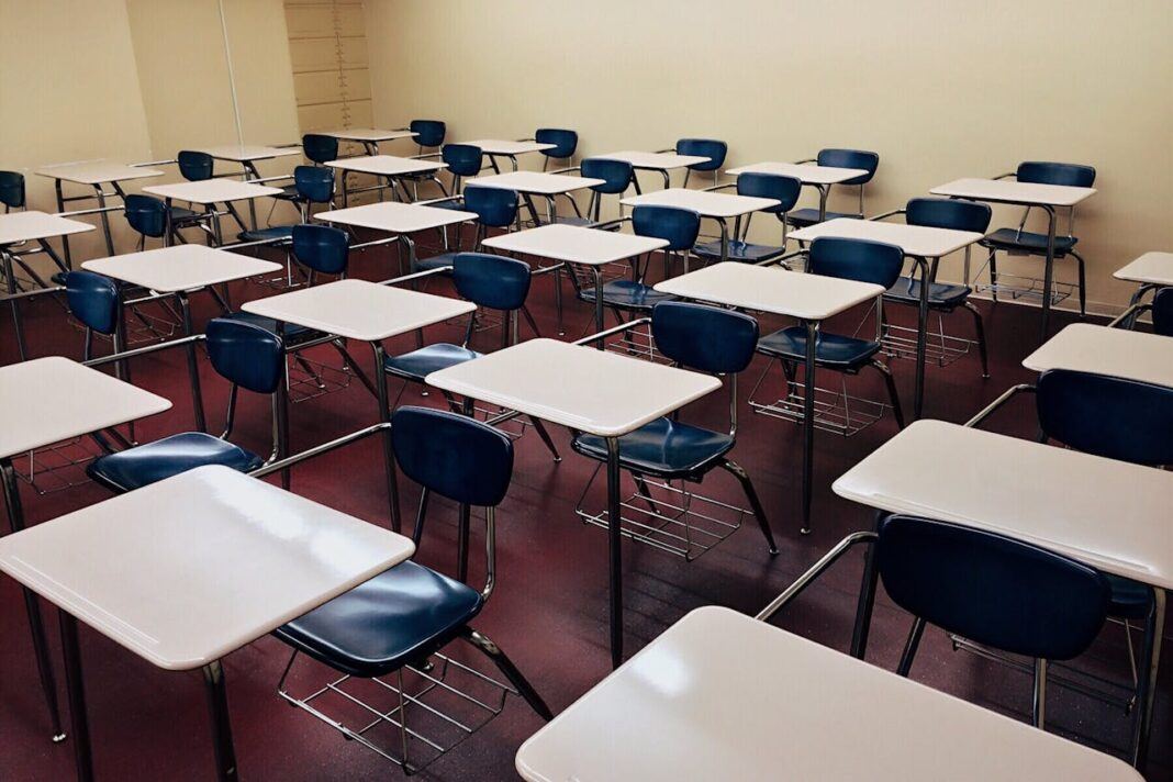 An empty classroom with desks and chairs arranged in rows