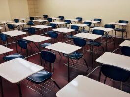 An empty classroom with desks and chairs arranged in rows