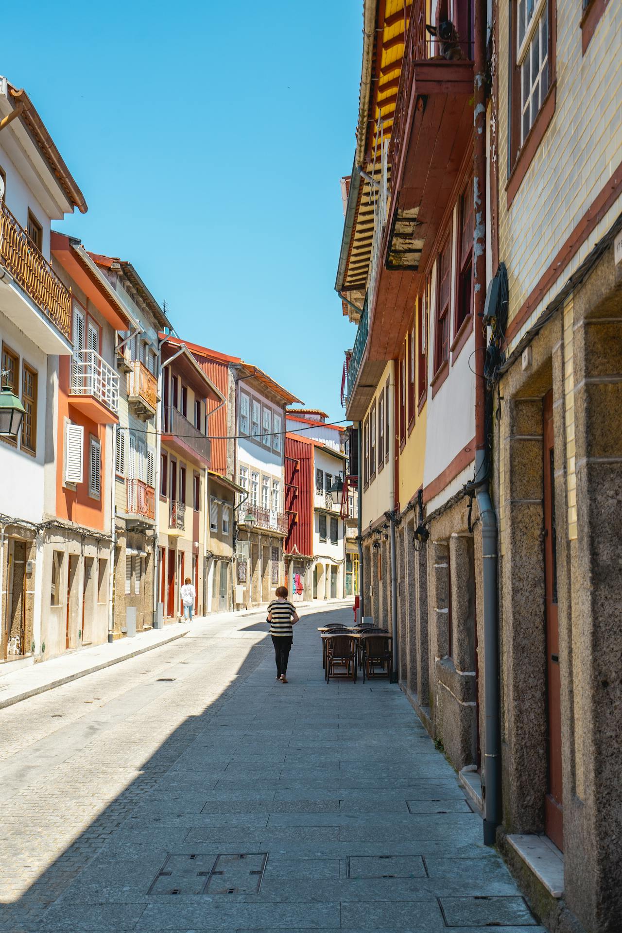 A street in Guimarães, Portugal with an older woman walking away