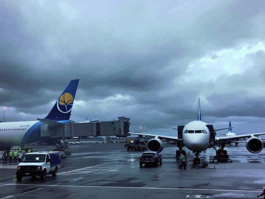 Lisbon Airport with cloudy skies and rain on runway.