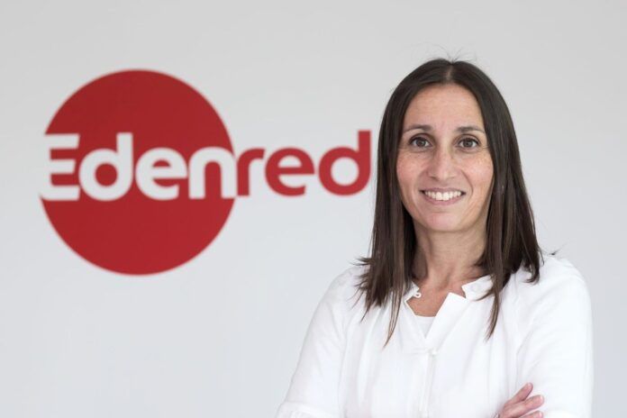 Filipa Martins in a business setting, smiling confidently with the Edenred logo on a wall behind her.