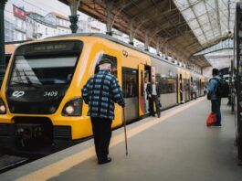 A CP train parked at a train station in Portugal as a few people disembark.