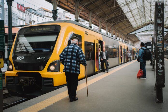 A CP train parked at a train station in Portugal as a few people disembark.