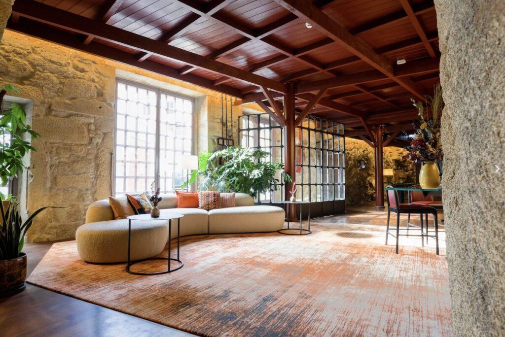 The reception or lobby area with a sofa and tables at the Hotel das Virtudes, Porto, Portugal.