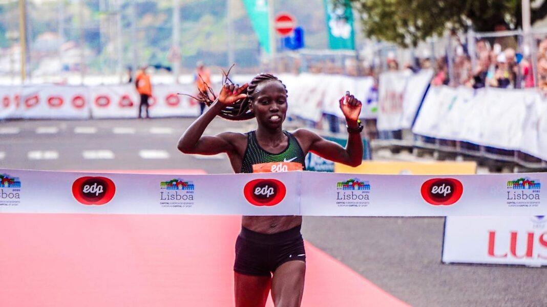 A female runner crosses the line at the end of a race.