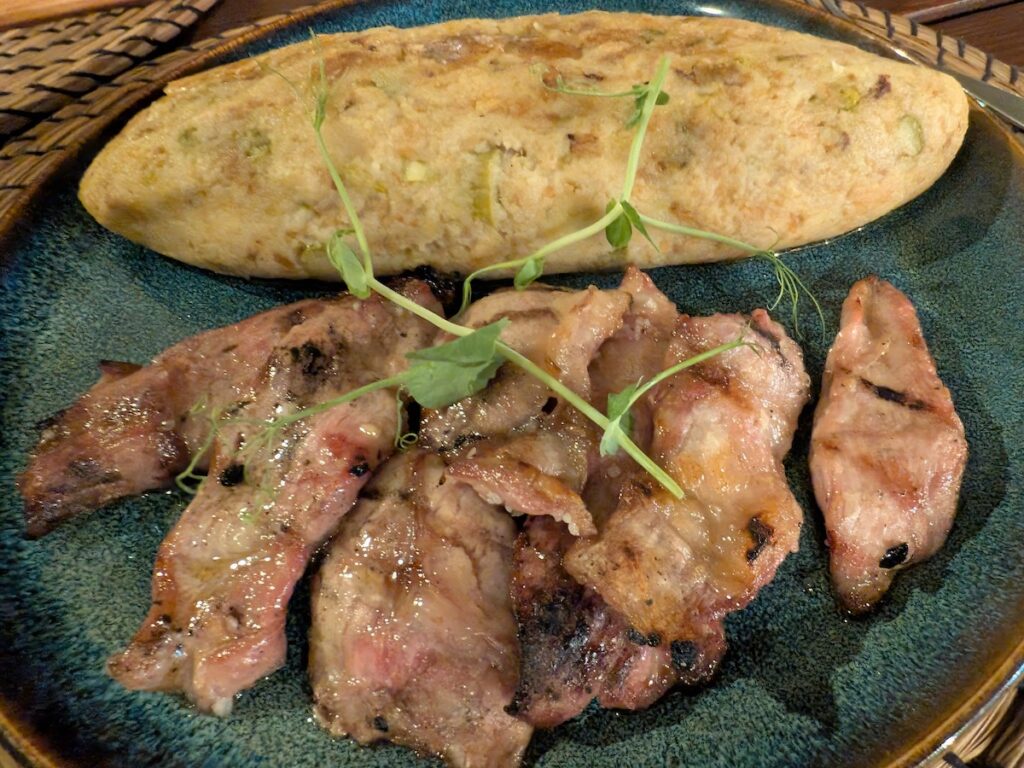 The Portuguese dish of migas with pork steaks seen on a white plate