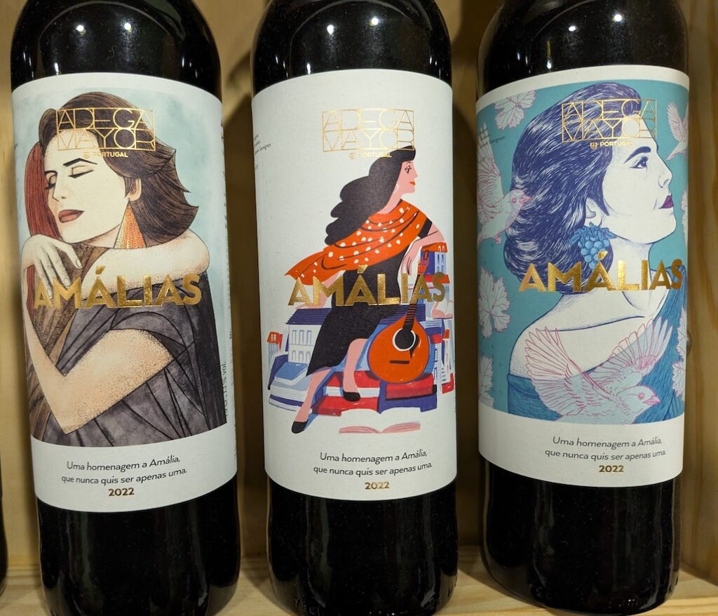 Three wine bottles with colorful labels showing women on the labels