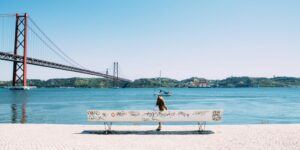 woman sitting on white bench in front of sea