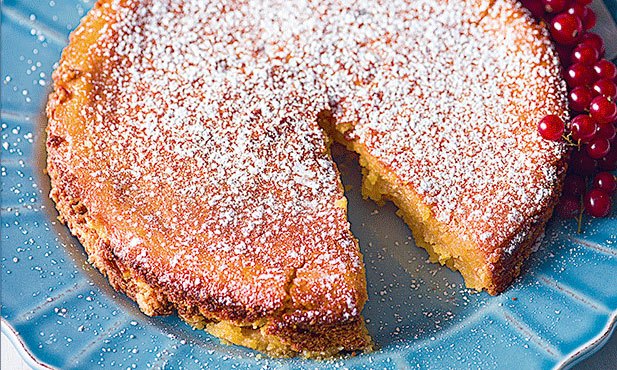  Toucinho Do Céu cake on a blue tablecloth with icing sugar on top