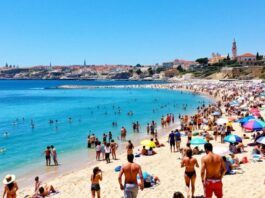 Tourists enjoying sunny beaches in Portugal with colorful umbrellas.