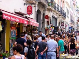 Busy Martim Moniz street with shops and people.