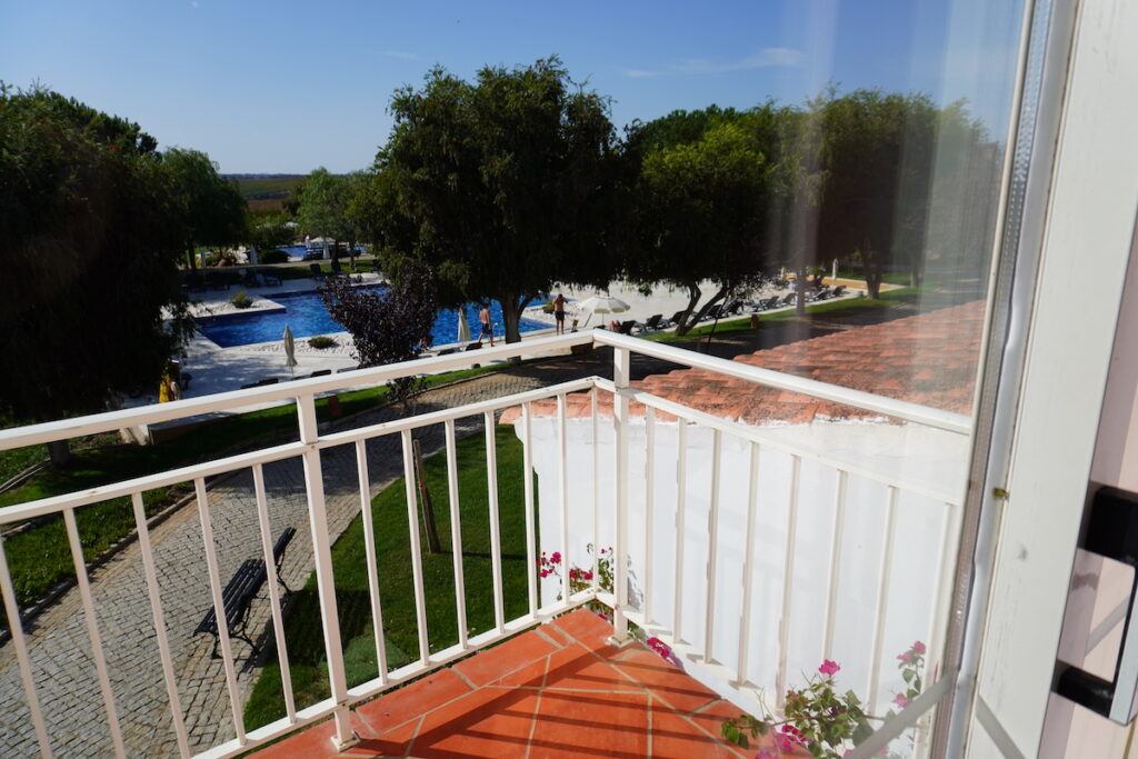 A view of a hotel swimming pool from a room balcony