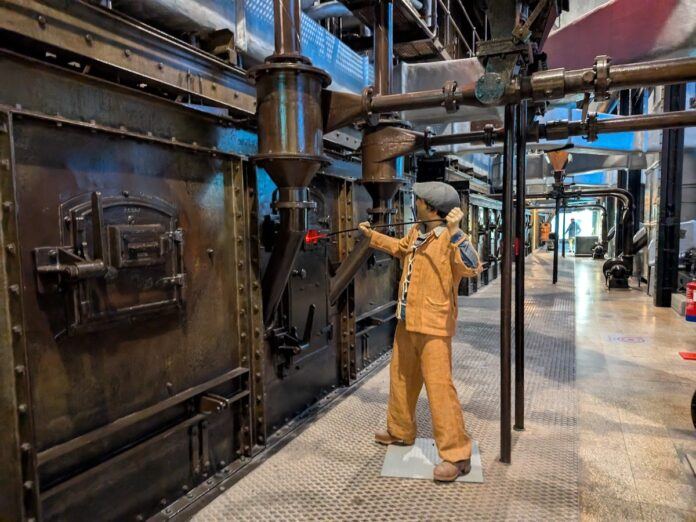 A mannequin shovels coal in to a furnace at a museum exhibition