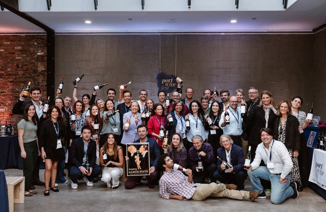 Exhibitors pose with bottles of Port for a group photo at Port Wine Fest October 2024