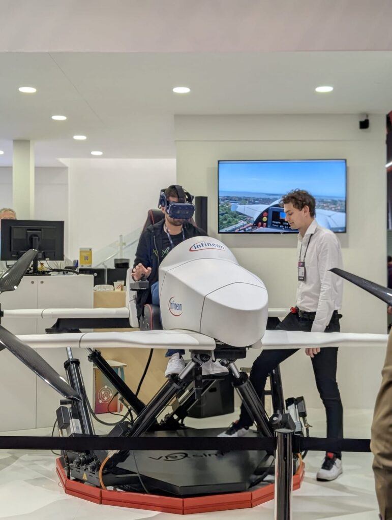 One man sits in a small aircraft prototype while another looks on.