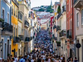 Colorful Lisbon street with residential buildings and people.