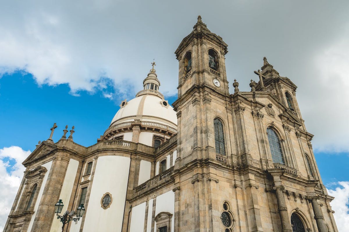 A church seen from ground level against a blue and white cloudy sky.