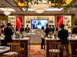 Asian sommeliers discussing wine in an elegant setting.