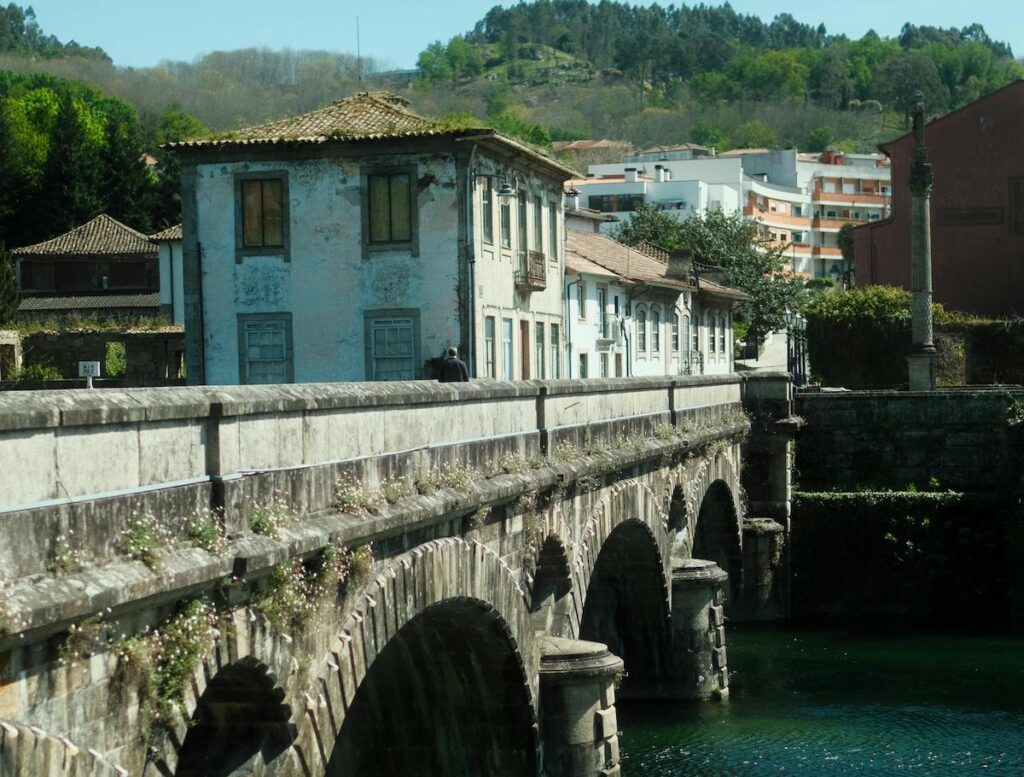 A bridge across a river, with a house and hill in in the background, in Arcos de Valdevez, Portugal.