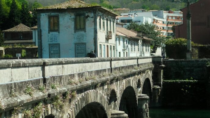 A bridge across a river, with a house and hill in in the background, in Arcos de Valdevez, Portugal.