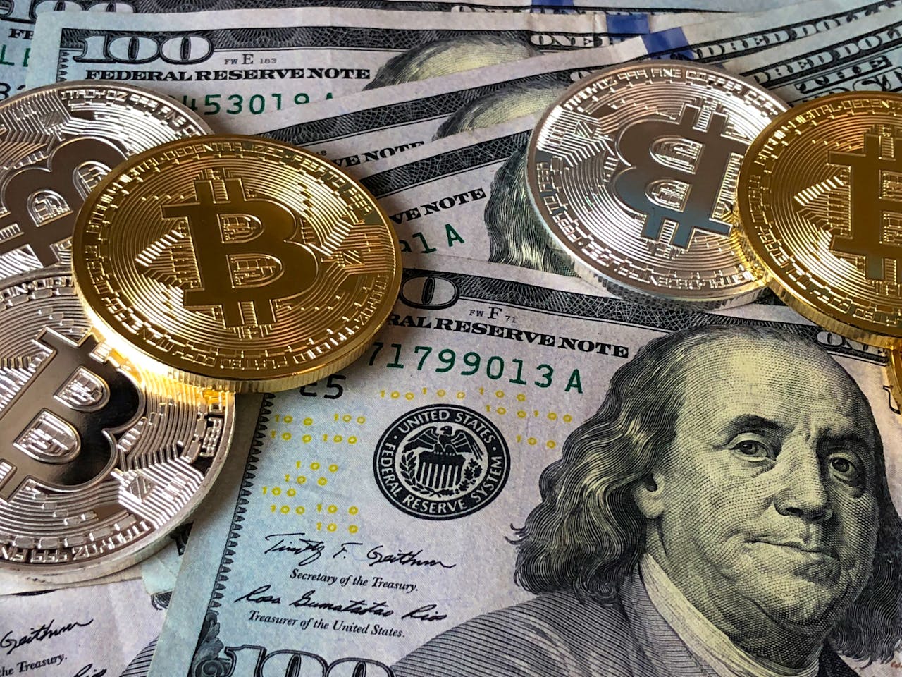 US dollar notes with coins, with the Bitcoin logo on them.