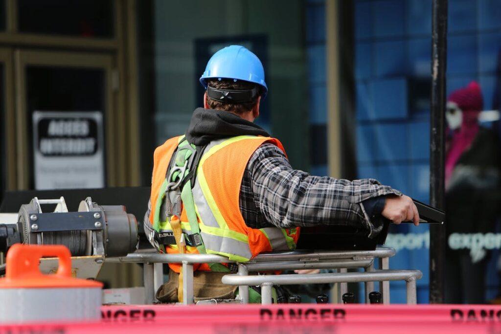 A worker in a hi-viz jacket and hard-hat works in an industrial setting