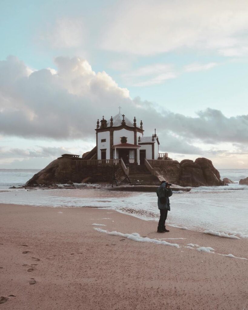 Man Standing at the Beach Near Dome Building