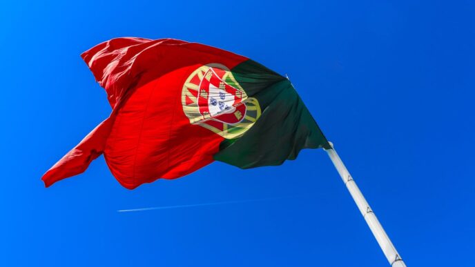 A Portuguese flag seen blowing against a blue sky