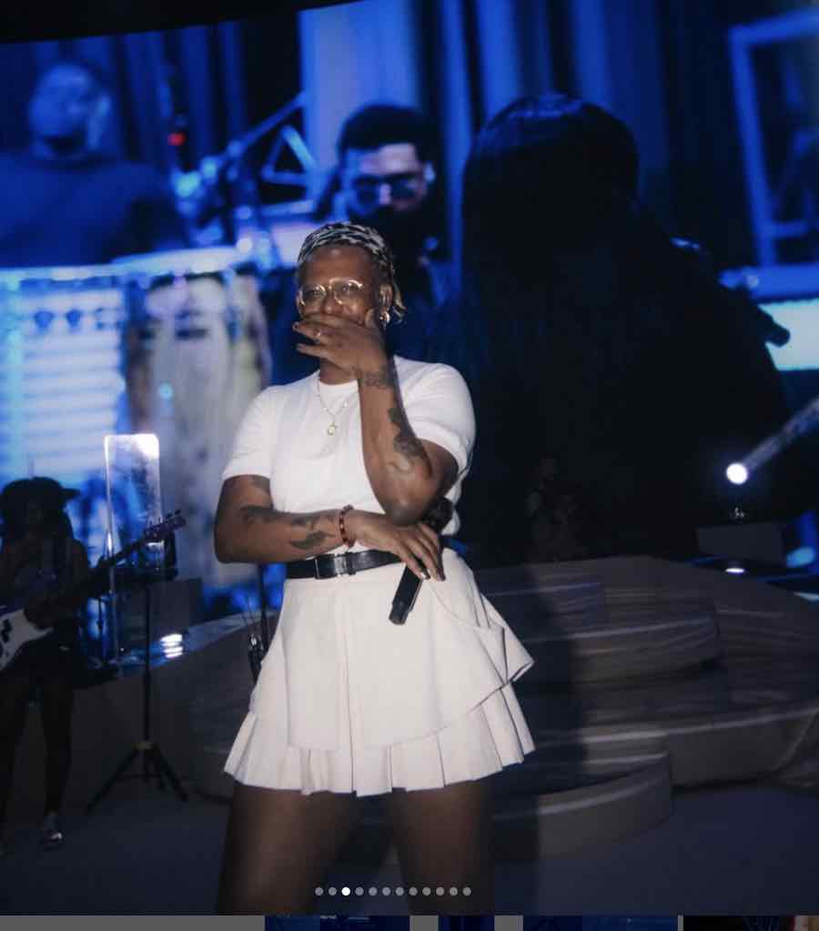 The singer Liniker poses for a photo backstage, dressed in white