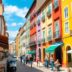 Vibrant streets of Portugal with colorful architecture and locals.