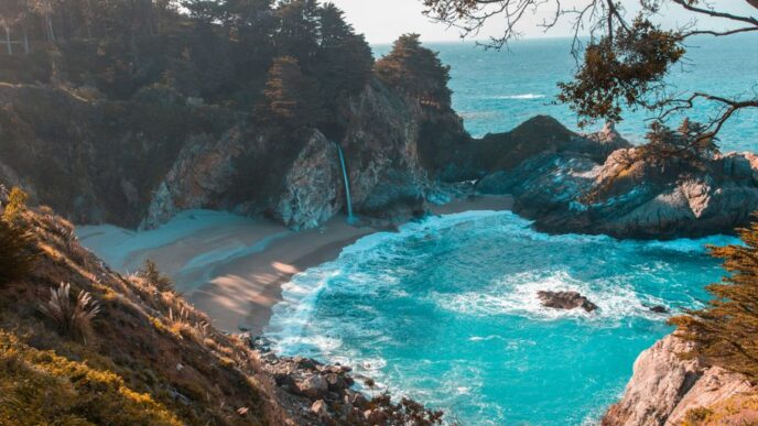 body of water near trees and mountain cliff during daytime