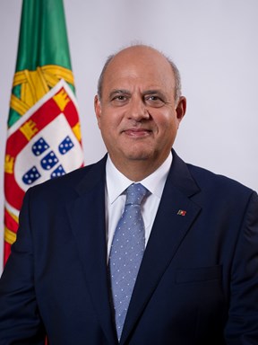 Carlos Costa Neves in front of a Portuguese flag