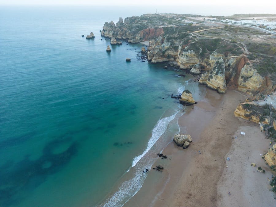 A beach in Lagos, Portugal seen from a cliff-top angle