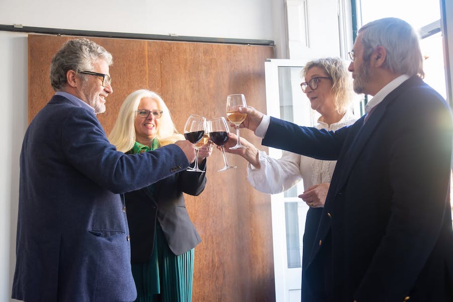 People clinking wine glasses in a room