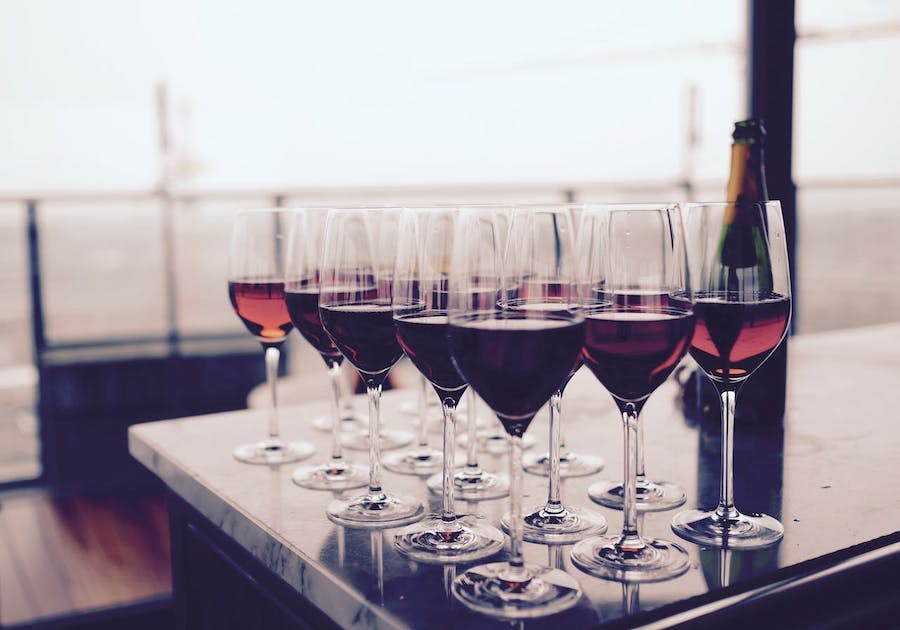 Glasses with red wine are assembled on a table ready for tasting