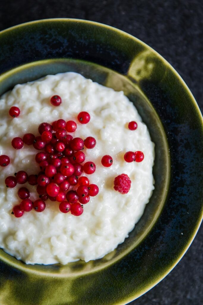 Rice pudding in a dish with red fruit on the top