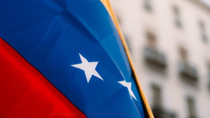 The flag of Venezuela on blows in the wind, with a building out of focus behind