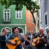 Musicians performing in a colorful Lisbon street.